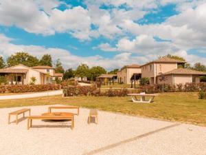 a park with a bench and a table and houses at Spacious and modern villa with large garden and BBQ area in Les Forges