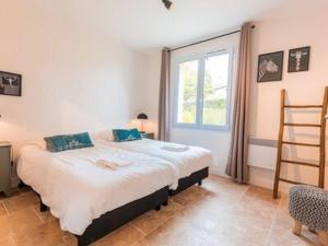 a bedroom with a large bed and a window at Spacious and modern villa with large garden and BBQ area in Les Forges