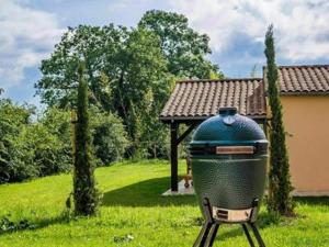 a grill sitting in the grass in a yard at Spacious and modern villa with large garden and BBQ area in Les Forges
