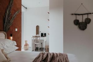 a bedroom with a white bed and a table at Villa Calma - Maison d'hôtes & Spa in Mottier