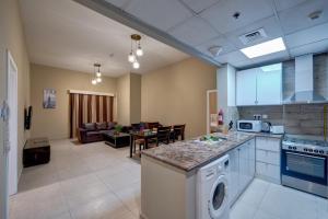 a kitchen and living room with a stove and a dishwasher at City Stay Residences - Serviced Apartments DIP in Dubai