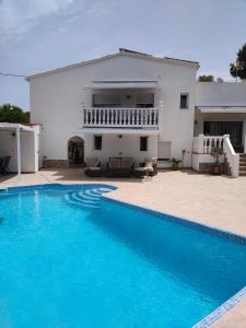 a villa with a swimming pool in front of a house at VILLA " VISTA JAVEA "- Home away from home in Jávea