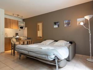 a bedroom with a large bed and a kitchen at Nice studio with included linen package in the Loire in Saumur