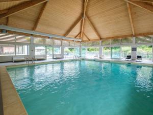 a large swimming pool with blue water in a building at Nice studio with included linen package in the Loire in Saumur