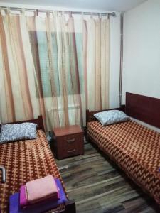 two beds sitting in a room with curtains at PAJO in Sutomore