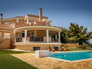 uma casa grande com uma piscina em frente em Grand villa on top of a hill with endless bay views, private pool, south coast em Ambelókipoi