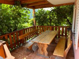 - une table de pique-nique en bois sur une terrasse avec des arbres dans l'établissement Apartma Kresnička, à Kobarid