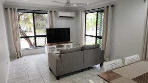 sala de estar con sofá y TV de pantalla plana en WhitsunStays - The Goose Ponds en Mackay