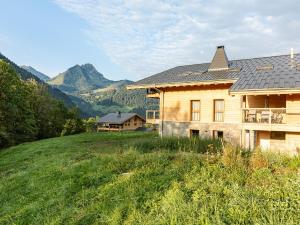 a house on a hill with mountains in the background at Alpine Retreat w Sauna in Abondance