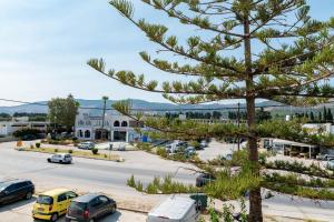 a view of a parking lot with a pine tree at oiKOS Hospitality in Kos