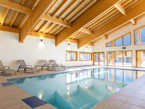 a large indoor pool with chairs and wooden ceilings at Apartment in France near Scenic Mountains in Abondance
