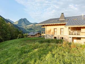 a house on a hill with mountains in the background at Apartment in France near Scenic Mountains in Abondance