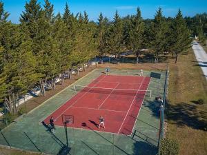 a group of people playing tennis on a tennis court at Bungalow in France with Private Garden in Mauroux