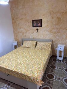 una camera da letto con un letto con una croce sul muro di Piccola Dimora Villa Candido a Stilo