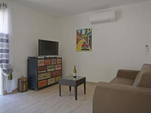 ein Wohnzimmer mit einer Couch, einem Fernseher und einem Tisch in der Unterkunft Villa in Montauroux with Pool & Near Forest in Montauroux