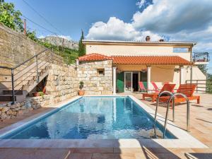 a swimming pool in front of a house at Villa in Solin with Private Pool and Garden in Solin