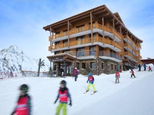 - un groupe de personnes skier devant un lodge de ski dans l'établissement Luxury apartment with a balcony in the lively Arc 2000, à Arc 1950