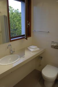 baño con lavabo y aseo y ventana en Hotel Celisol Cerdagne, en Bourg-Madame