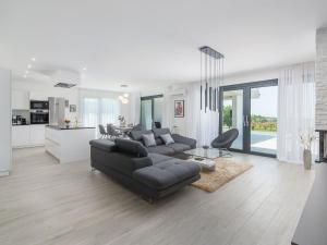 a living room with a black couch and a kitchen at Apartment in Croatia near the Coast in Brtonigla