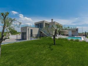 a house with a swimming pool and a green yard at Apartment in Croatia near the Coast in Brtonigla