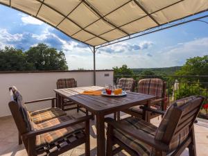 a table and chairs on a patio with a view at Villa in Kujici near Beach with Pool in Hreljići