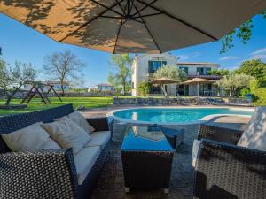 - une terrasse avec un parasol à côté de la piscine dans l'établissement Beautiful villa with swimming pool and fenced garden, à Tinjan