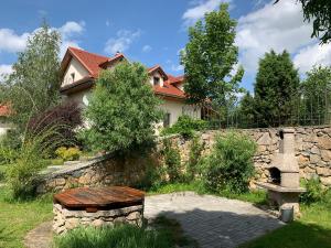 a stone wall with a bench in front of a house at Villa Lypche in Bešeňová