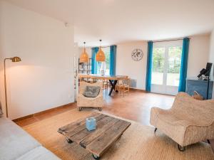 sala de estar con mesa de madera y sillas en Spacious and modern villa with large garden and BBQ area en Les Forges