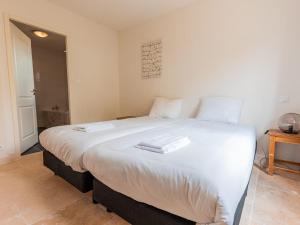 1 cama blanca grande con 2 toallas blancas. en Spacious and modern villa with large garden and BBQ area en Les Forges