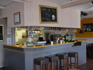 a bar with stools in a restaurant at Safari Tent at Vlugtenburg Beach in 's-Gravenzande +29 photos