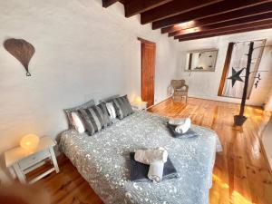 um quarto com uma cama e piso em madeira em Charming Finca with beautiful private gardens em Uga