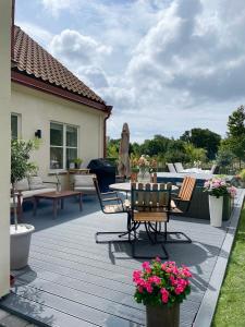 patio ze stołem, krzesłami i kwiatami w obiekcie Villa Lysholmen w mieście Särö