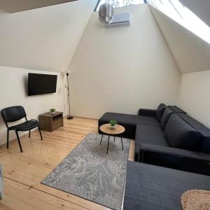 uma sala de estar com um sofá preto e uma televisão em Planinske Kuće Grocka em Grocka