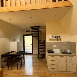 uma cozinha com uma mesa e uma escada num quarto em Planinske Kuće Grocka em Grocka