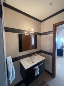 La salle de bains est pourvue d'un lavabo et d'un miroir. dans l'établissement Superbe appartement en résidence, Meublé a louer., à Agadir