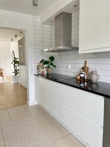eine Küche mit weißen Schränken und schwarzen Arbeitsplatten in der Unterkunft Villa Lysholmen in Särö