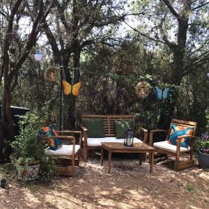 a group of chairs and a table and butterflies hanging from trees at Roulotte Fenouillet in Hyères