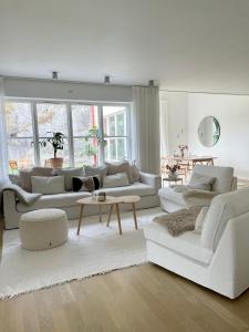 a white living room with white couches and a table at Villa Lysholmen in Särö