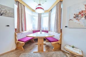 a dining room with a table and purple chairs at Apartments Culac in Santa Cristina Gherdëina