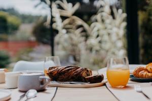 a table with a plate of food and orange juice at Villa Calma - Maison d'hôtes & Spa in Mottier