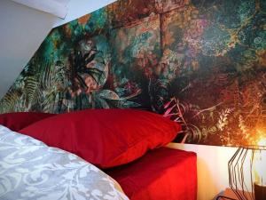 a bedroom with a painting on the wall and red pillows at Duplex Cosy Place République in Lille