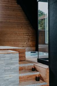 a wooden house with a swimming pool and a window at Villa Calma - Maison d'hôtes & Spa in Mottier