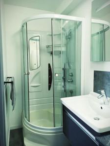 uma casa de banho com uma cabina de duche em vidro e um lavatório. em Duplex Cosy Place République em Lille