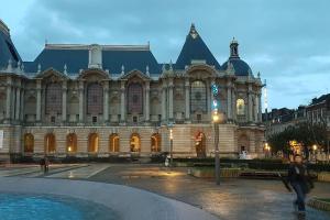 a large building with a fountain in front of it at Duplex Cosy Place République in Lille