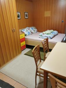 a room with two beds and a table and chairs at Pocket apartment Rogla - Gaber 121 in Zreče