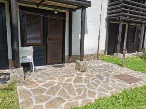 un patio de piedra con una silla frente a un edificio en Pocket apartment Rogla - Gaber 121 en Zreče