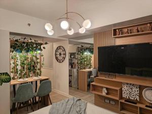 a living room with a flat screen tv and a dining room at azuresky condotel in Lagundi