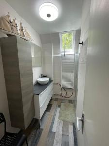 a white bathroom with a sink and a window at Le Cognet : Maison 190 m2 Home 190 sqm 18' from Caen - 35 ' from Bayeux 