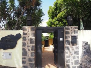 una puerta abierta a un edificio con palmeras en Luxury Canarian villa with large pool and apartment in Costa Teguise en Teguise