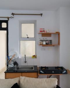 a kitchen with a sink and a stove and a window at Lux Suites Racecourse Gardens Studio Apartments in Nairobi